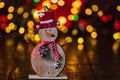 Christmas decorations against blurred background and out of focus lights. Decorative wooden snowman and glittery Christmas balls Royalty Free Stock Photo