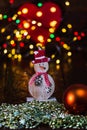 Christmas decorations against blurred background and out of focus lights. Decorative wooden snowman and glittery Christmas balls Royalty Free Stock Photo