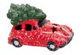 Christmas decorations background. Closeup of a snow-covered red car toy with green fir-tree on the roof isolated on a white Royalty Free Stock Photo