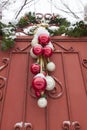 Christmas decorations - balls and spruce branches, over the gate to the house. Beautiful house number