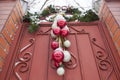 Christmas decorations - balls and spruce branches, over the gate to the house