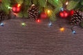 Christmas decorations with branches of fir tree, christmas lights, ball and Pine cones on wooden background. copy space Royalty Free Stock Photo