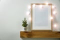 Christmas decorations in bright shiny colors with Christmas lights and frame picture. Wooden shelf and white wall background.