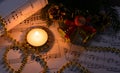 Christmas decorations, burning candle and sheet music Royalty Free Stock Photo