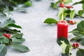 Christmas decorations, candle and holly leaves with red berries. Royalty Free Stock Photo