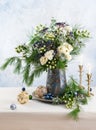 Christmas decorations, candles and flower bouquet. Winter arrangement with roses, fir branches, winter berries. Christmas flower Royalty Free Stock Photo