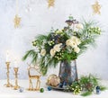 Christmas decorations, candles and flower bouquet. Winter arrangement with roses, fir branches, winter berries. Christmas flower Royalty Free Stock Photo