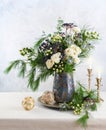 Christmas decorations, candles and flower bouquet. Winter arrangement with roses, fir branches, winter berries. Christmas flower Royalty Free Stock Photo