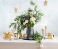Christmas decorations, candles, gift boxes and flower bouquet. Winter arrangement with roses, fir branches, winter berries. Royalty Free Stock Photo