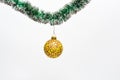 Christmas decorations concept. Ball with ornaments hang on shimmering green tinsel. Tinsel with pinned christmas toy