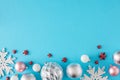 Flat lay composition of silver pink christmas baubles, stars and snowflakes on pastel blue background Royalty Free Stock Photo