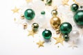 Christmas decorations concept. Top view photo of pine branches in the snow with gold-green transparent baubles star ornaments and Royalty Free Stock Photo