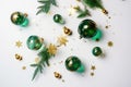 Christmas decorations concept. Top view photo of pine branches in the snow with gold-green transparent baubles star ornaments and Royalty Free Stock Photo