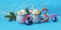 Christmas decorations, a couple of cups of coffee with meringues on a blue background