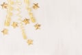 Christmas decorations, curl ribbon and gold stars falling on soft white wooden background. Royalty Free Stock Photo