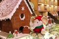 Christmas Decorations with Cute Elephant Soft Toy in Santa Costume and Marzipan Snowman in front of Gingerbread House