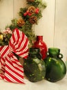 Christmas decorations.. evergreen wreath, pine cones, berries, green glass vases, red vase Royalty Free Stock Photo