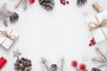 Christmas decorations fall on the white table concept. Gifts, pine, cones, red berries, tree branches, snowflakes