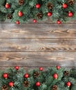 Christmas decorations with fir branches, red balls and cones on wooden background. Flat lay, top view, copy space Royalty Free Stock Photo