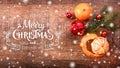 Christmas decorations with fir tree branch and tangerines on wooden background with snow, blurred Royalty Free Stock Photo