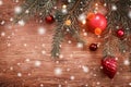 Christmas decorations with fir tree branch on wooden background with snow, blurred, sparking with space for text Royalty Free Stock Photo