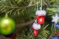 christmas decorations with fir tree branches, red santa gloves toys hanging on christmas tree