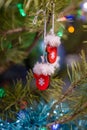 christmas decorations with fir tree branches, red santa gloves toys hanging on christmas tree
