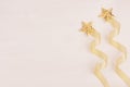 Christmas decorations, firework of gold stars and curl ribbon on soft white wooden background. Royalty Free Stock Photo