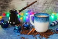 Christmas decorations garland cup of coffee with milk cinnamon sticks scattered coffee beans and black ceramic Cezve Royalty Free Stock Photo