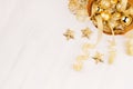 Christmas decorations, gold stars, balls and ribbons on soft white wooden background, copy space. Royalty Free Stock Photo