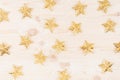 Christmas decorations, gold stars on soft beige wooden background. Royalty Free Stock Photo