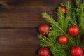 Christmas decorations with green branches and christmas balls on the rustic wooden background. Shot from above Royalty Free Stock Photo