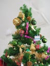 Christmas decorations green tree hanging, gold Gift box, green ball, brown Pine cones, socks, footwear, pink bell wrapped around Royalty Free Stock Photo