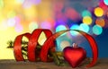 Christmas decorations with heart shape, red ribbon under defocused background. Royalty Free Stock Photo