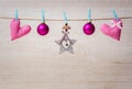 Christmas decorations and hearts hanging on rope on wooden background