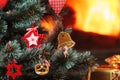 Christmas decorations hung on the tree. Blazing fireplace in the background Royalty Free Stock Photo