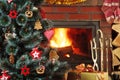 Christmas decorations hung on the tree. Blazing fireplace in the background Royalty Free Stock Photo