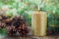 Christmas decorations with lighted candle, pine cones and fir branches on wooden background with magic bokeh effect, Christmas car