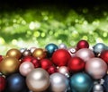 Christmas decorations, pile of glass colored balls isolated on blurred green bright lights, useful as a greeting gift card Royalty Free Stock Photo