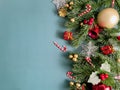 Christmas decorations, pine tree leaves, golden balls, snowflakes, golden berries and red berries on blue background Royalty Free Stock Photo