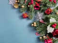 Christmas decorations, pine tree leaves, golden balls, snowflakes, red berries and golden berries on blue background Royalty Free Stock Photo