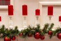 Christmas decorations and red candles stand on the fireplace Royalty Free Stock Photo