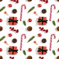 Christmas decorations seamless pattern on a white background. Gifts, fir branches, berries and lollipops. Winter concept. Top view Royalty Free Stock Photo