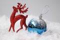 Christmas decorations. Shiny Christmas red deer and blue ball on snow decorations Royalty Free Stock Photo