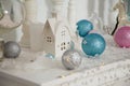 Christmas decorations, silver, blue and pink bulbs, white candles, wooden house and rocking horse toy Royalty Free Stock Photo