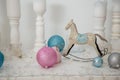 Christmas decorations, silver, blue and pink bulbs, white candles, wooden house and rocking horse toy Royalty Free Stock Photo