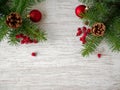 Christmas decorations. Spruce branches, red balls, cones and Rowan berries on a light wooden background. Royalty Free Stock Photo