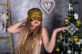 Christmas decorations in studio and woman in masquerade mask Royalty Free Stock Photo