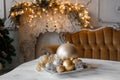 Christmas decorations on the table against the background of a fireplace decorated with branches spruce and garland. Royalty Free Stock Photo