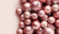 Christmas decorations, top view of pile of glass balls colored in blush pink, isolated on pink background, useful as a greeting